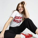 Person wearing a white Roberts Wesleyan t-shirt with red text, black pants, and red sneakers on a white background