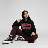 Person wearing a black hoodie with 'Roberts Wesleyan' text, sitting on a white background